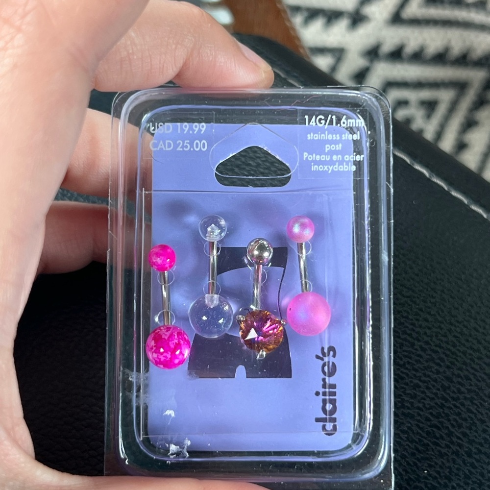 Multiple bellybutton rings in a verity of pinks and silver
